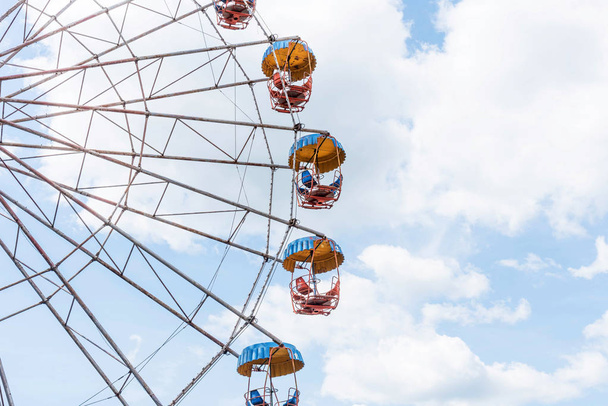 Colorful ferris wheel on the background of cloudy blue sky. - Fotoğraf, Görsel