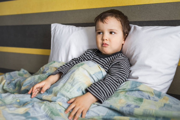 disappointed sick child boy sitting on bed - Foto, Imagem