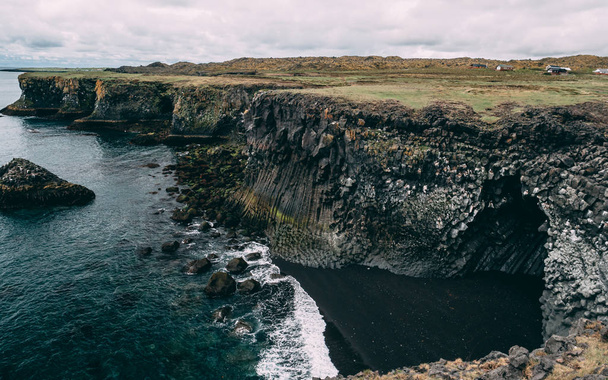 Mořské útesy západního pobřeží Snaefellsnes poloostrova. krásné malebné islandské pobřeží útes s malebného sopečného kamene - Fotografie, Obrázek