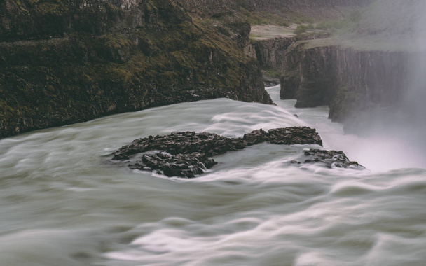 Водопад Гульфосс в леднике с гладкой водой длительное время воздействия скалистых
 - Фото, изображение