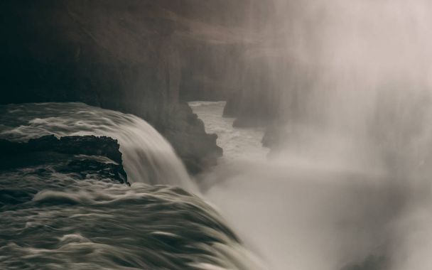 Водопад Гульфосс в леднике с гладкой водой длительное время воздействия скалистых
 - Фото, изображение