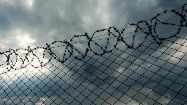 Czas wygaśnięcia, szare chmury latające nad ogrodzeniem z więzienia. - Materiał filmowy, wideo
