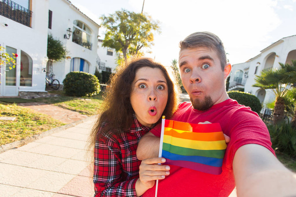 Gay en lesbische vriendschap holding Regenboogvlag - Foto, afbeelding