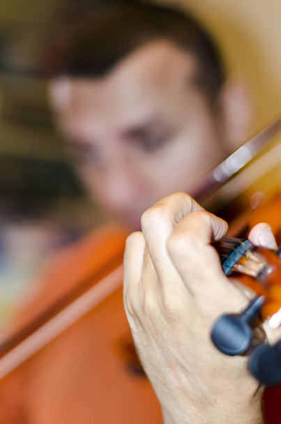 Чоловічий музикант, грає скрипка на темному тлі - Фото, зображення