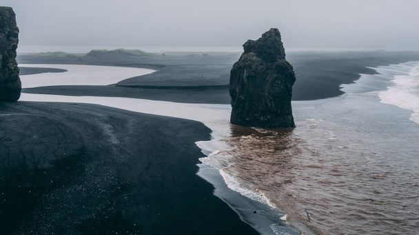 Spiaggia di sabbia nera in ghiandaia con grande roccia e clima nebbioso scogliera
 - Foto, immagini
