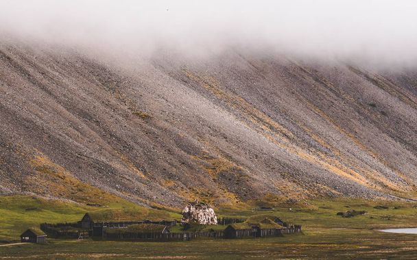 Vanha viikinkikylä Islannissa sumuisella kukkulalla. vanhat puurakennukset katettu ruoho
 - Valokuva, kuva