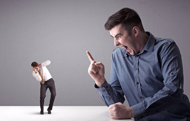 Young businessman fighting with miniature businessman - Photo, Image