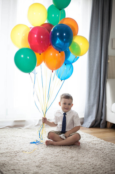 Nelivuotiaan pojan muotokuva, jolla on ilmapalloja. Syntymäpäivä. Onnellinen lapsi puvussa. Rakkaus
. - Valokuva, kuva