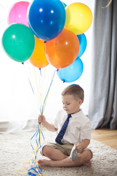 Πορτρέτο του ένα όμορφο αγόρι 4 ετών με μπαλόνια. Γενέθλια. Ευτυχισμένο παιδί σε ένα κοστούμι. Αγάπη. Άνετο. - Φωτογραφία, εικόνα