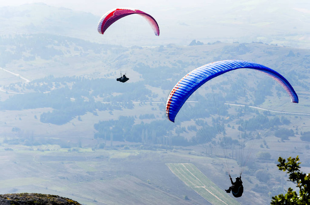 PRILEP, MACEDONIA - circa FEB, 2017: Paragliding high over valley at daytime - Foto, immagini