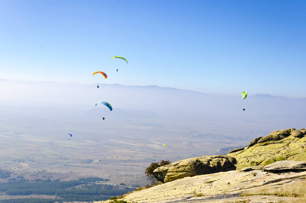 Paragliders flying on blue sky background  - Foto, imagen