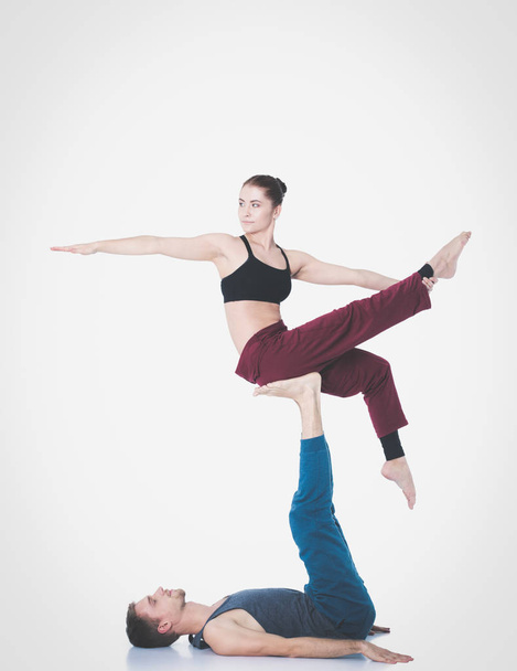 Young athletic couple practicing acroyoga. Balancing in pair. - Fotoğraf, Görsel