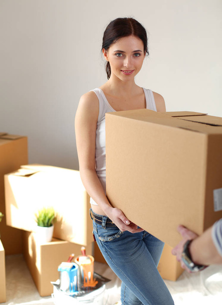 Happy young couple unpacking or packing boxes and moving into a new home. young couple - Foto, Imagen