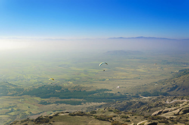 Paragliders flying on blue sky background  - Photo, image
