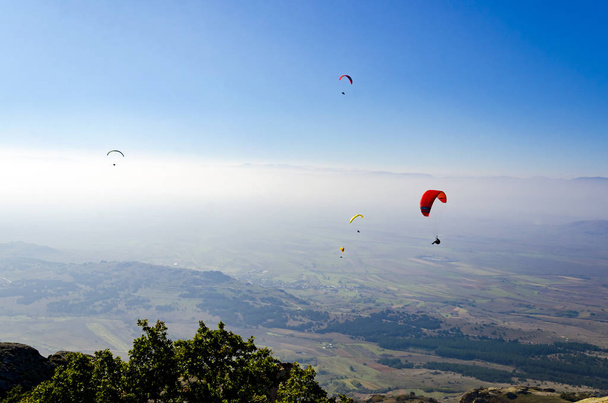 Paragliders flying on blue sky background  - Zdjęcie, obraz
