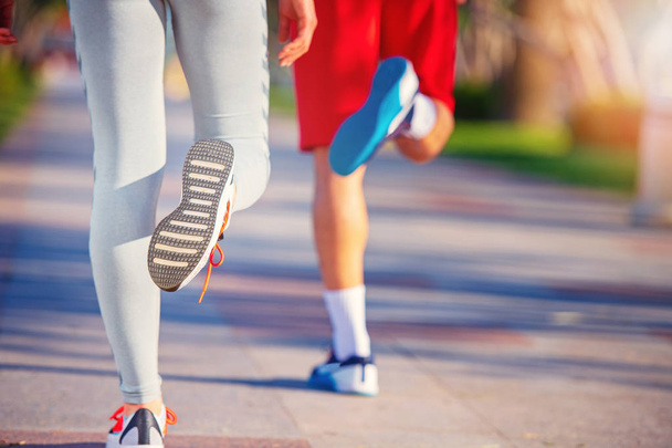 legs of man and woman  in sportswear jogging at beach, back view  - Zdjęcie, obraz