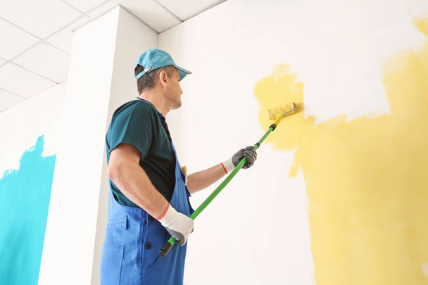 Pintor masculino em uniforme trabalhando dentro de casa
 - Foto, Imagem