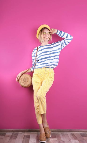Beautiful young woman posing near color wall. Summer fashion - Photo, image