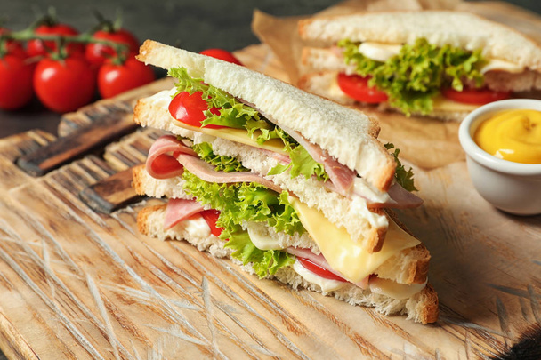Tasty toast sandwich on wooden board. Wheat bread - Foto, imagen