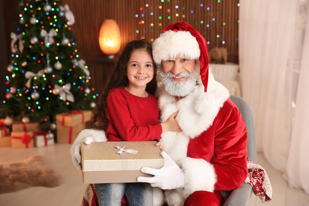 Little child with Santa Claus and Christmas gift at home - Fotó, kép