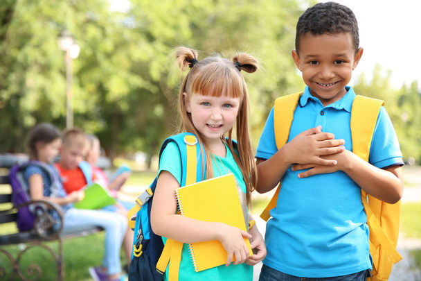 Lindos niños pequeños con mochilas al aire libre. Escuela primaria
 - Foto, imagen