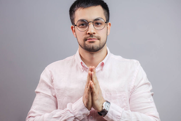 a young handsome businessman keeping palms in praying pose - Фото, изображение