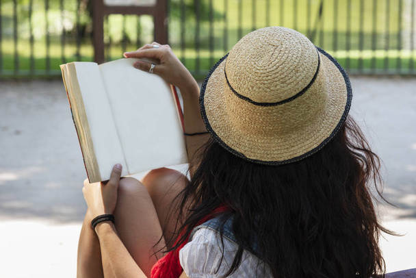 giovane donna che legge un libro, seduta su una panchina nel parco. Concetto rilassato
 - Foto, immagini