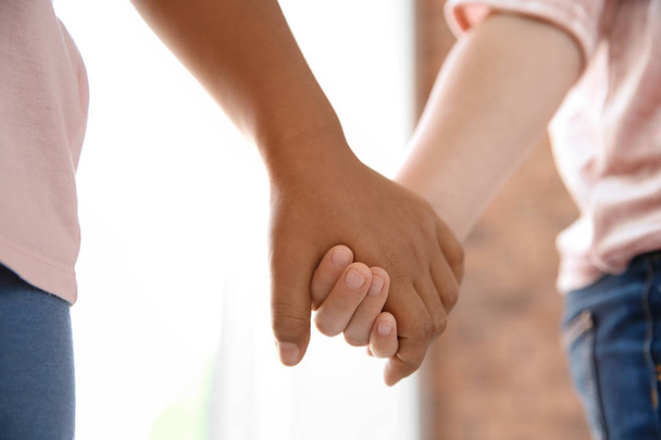Children holding hands on blurred background, closeup. Unity concept - Foto, Imagem