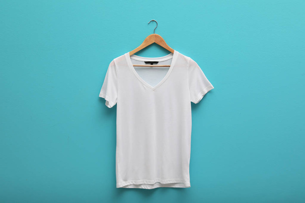 Hanger with blank t-shirt on color background. Mockup for design - Foto, afbeelding