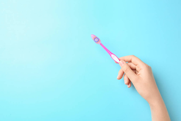 Woman holding manual toothbrush against color background - Φωτογραφία, εικόνα