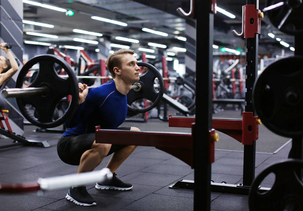 Athletic man training with barbell in modern gym - Fotoğraf, Görsel