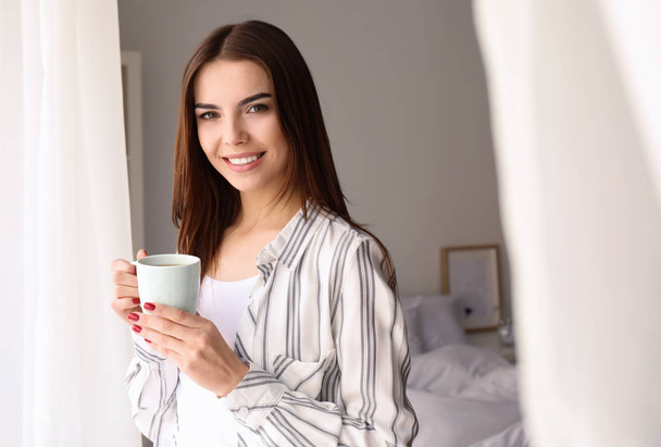 Το πρωί της όμορφη νεαρή γυναίκα που πίνει καφέ στο σπίτι - Φωτογραφία, εικόνα