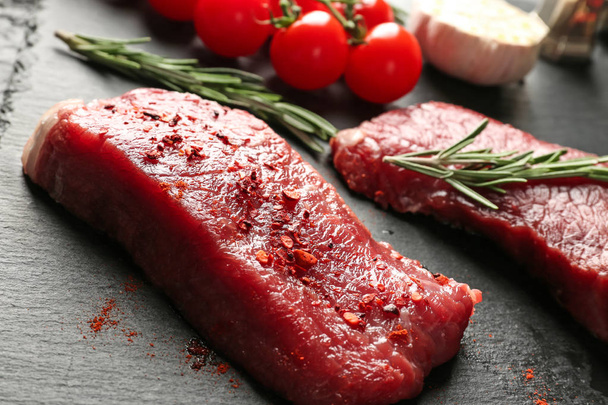Fresh raw meat with rosemary on slate plate - Fotó, kép