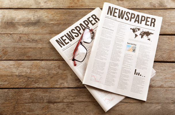 Jornais com óculos em fundo de madeira
 - Foto, Imagem
