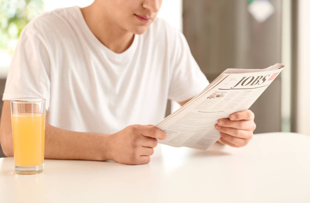 Чоловік читає газету на кухні
 - Фото, зображення