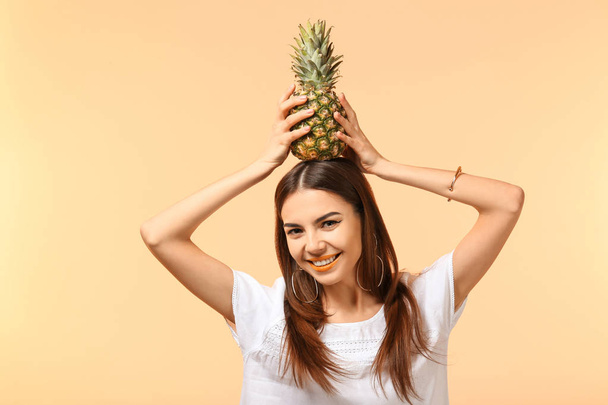Jovem atraente com abacaxi sobre fundo de cor
 - Foto, Imagem
