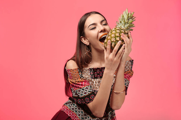 Attraente giovane donna con ananas su sfondo di colore
 - Foto, immagini