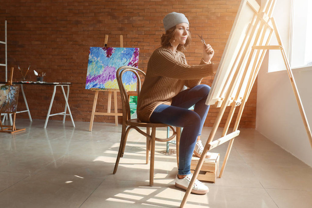 Female artist painting in workshop - Foto, immagini