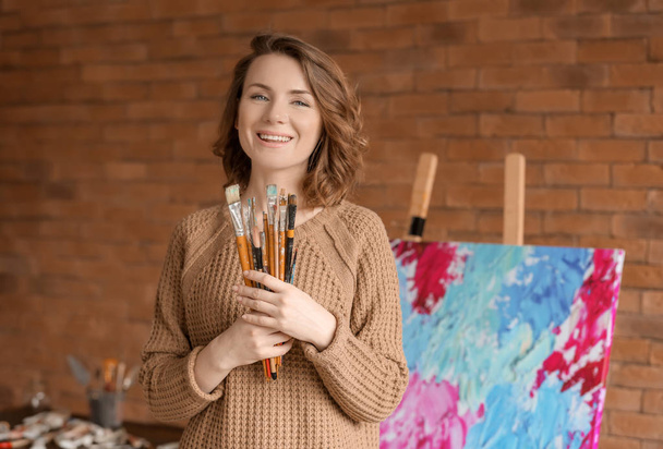 Artiste féminine avec pinceaux en atelier
 - Photo, image