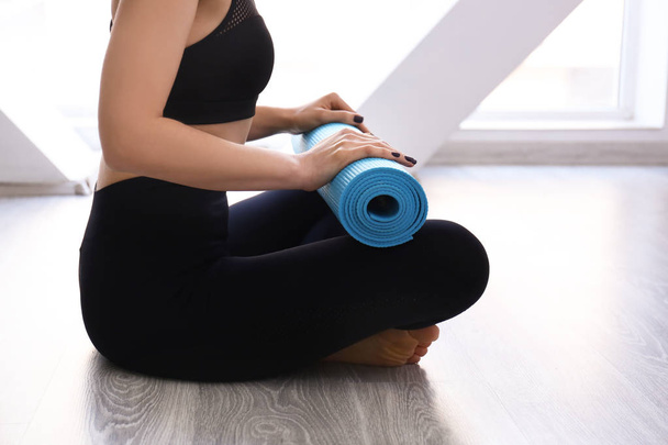 Jeune femme avec tapis de yoga à l'intérieur
 - Photo, image
