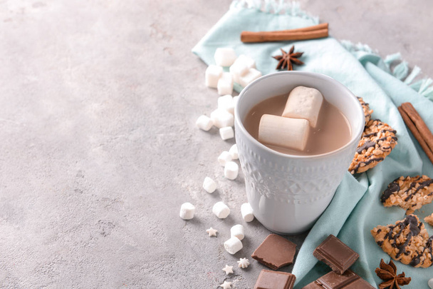 Copa de deliciosa bebida de cacao con malvaviscos y galletas en la mesa
 - Foto, Imagen