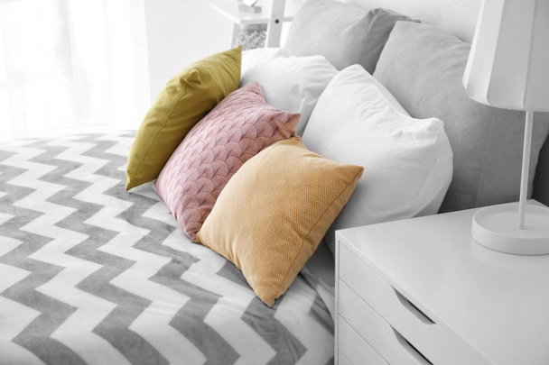 Удобная кровать с мягкими подушками в помещении
 - Фото, изображение
