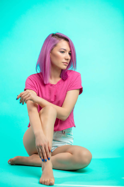 bright young beautiful girl with pink colored hair sitting on the floor - Photo, Image