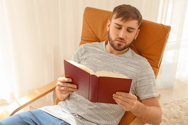 Young man reading book at home - Photo, Image