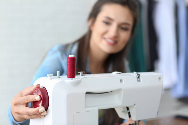 Genç kadın terzi dikiş makinesi atelier içinde kullanma - Fotoğraf, Görsel