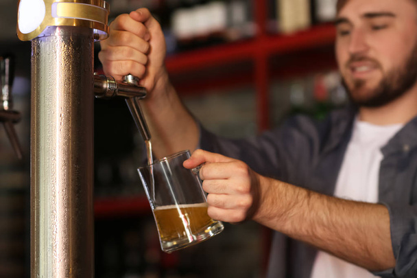 Barman bier gieten in glas in staaf - Foto, afbeelding