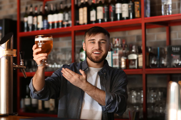 Bartender with glass of beer in bar - Fotografie, Obrázek