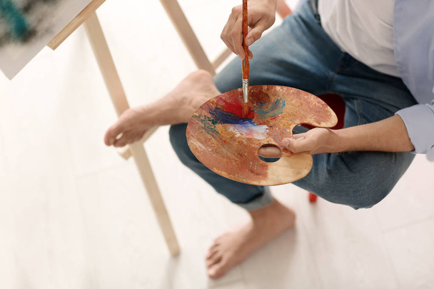 Чоловічий художник з пензлем і палітрою в майстерні
 - Фото, зображення