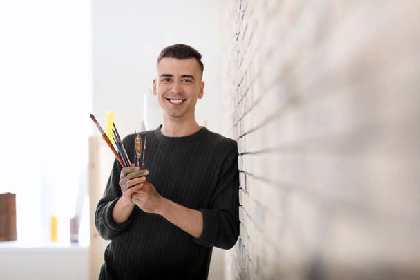 Artista masculino com pincéis em oficina
 - Foto, Imagem
