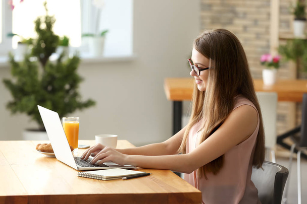 Libero professionista femminile che lavora su computer portatile in caffè
 - Foto, immagini